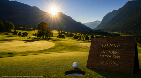 Golf course at sunset with a wooden sponsor sign reading 'DANKE AN UNSERE SPONSOREN' in the foreground, mountain valley in back.