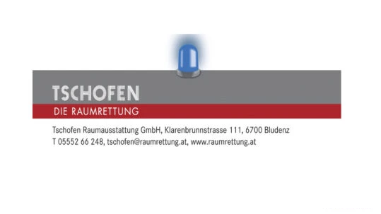 Sign/banner for Tschofen Raumrettung with grey top, red stripe, and contact details; a blue helmet rests on top of the sign.
